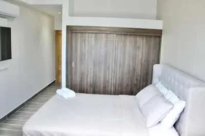 a bedroom with a white bed and a wooden wall at Acogedor y Moderno apartamento en Evaristo Morales in Colorado
