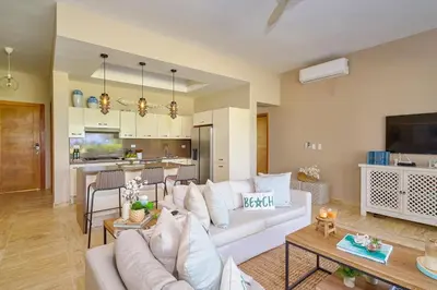 a living room with a white couch and a kitchen at ®{The~Beach~View} @PlayaBonita BeachfrontPool in Las Terrenas