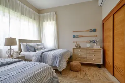 a bedroom with two beds and a dresser and a window at ®{The~Beach~View} @PlayaBonita BeachfrontPool in Las Terrenas