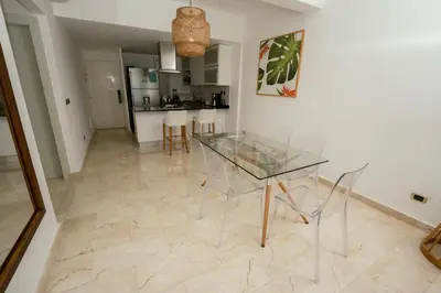 a dining room with a glass table and chairs at Apartamento moderno en Cana Rock - Punta Cana in Punta Cana