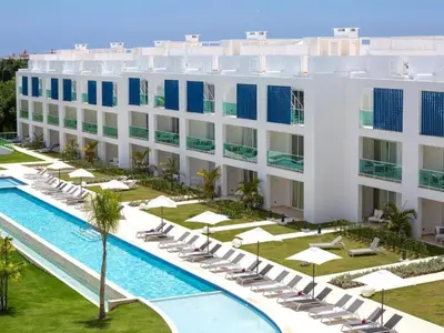 an aerial view of a hotel with a pool and chairs at Apartamento moderno en Cana Rock - Punta Cana in Punta Cana