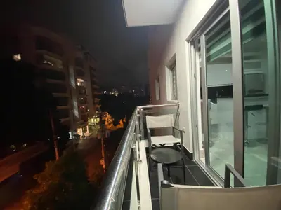 a chair on the balcony of a building at night at Soja 11 in Santiago de los Caballeros