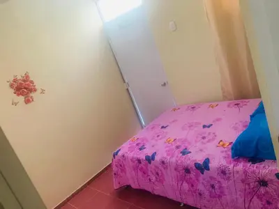 a small bedroom with a pink bed and a closet at Apartamento Mariela 4 in San Felipe de Puerto Plata