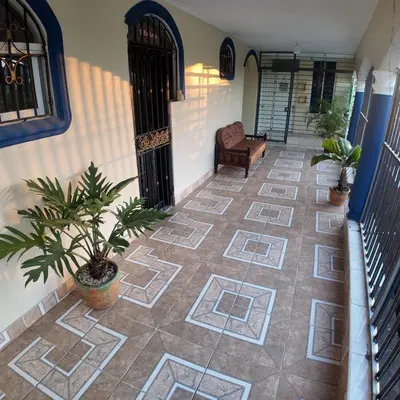 a porch with a tile floor with a chair and plants at Apartamento Mariela 4 in San Felipe de Puerto Plata