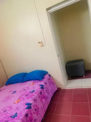 a small bedroom with a purple bed and a door at Apartamento Mariela 4 in San Felipe de Puerto Plata