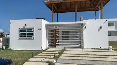 a white house with a door and a window at The Ocean Romana in La Romana