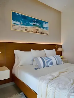 a bedroom with a large bed with white pillows at Costal View Apt. Walkable To Beach & Restaurants in Juan Dolio
