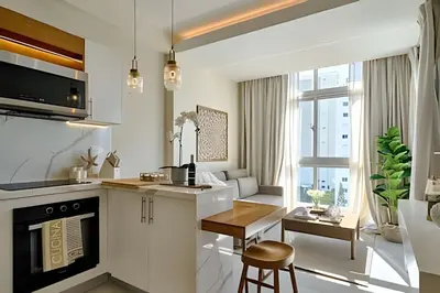 a kitchen and living room with a table and a stove at Costal View Apt. Walkable To Beach & Restaurants in Juan Dolio