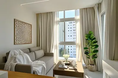 a living room with a couch and a large window at Costal View Apt. Walkable To Beach & Restaurants in Juan Dolio