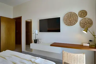 a living room with a tv on a wall at Costal View Apt. Walkable To Beach & Restaurants in Juan Dolio