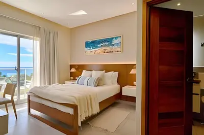 a bedroom with a bed and a view of the ocean at Costal View Apt. Walkable To Beach & Restaurants in Juan Dolio