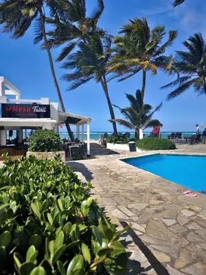 a resort with a swimming pool and palm trees at Chilvers Seaside Studio 202 in Cabarete