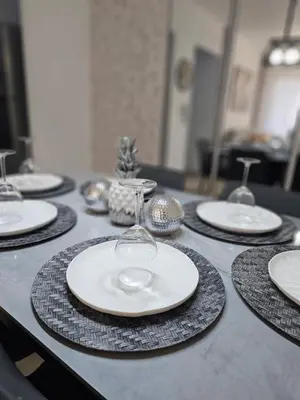 a table with white plates and wine glasses on it at Modern 3BR Apmt Near Airport & Beach in San Isidro