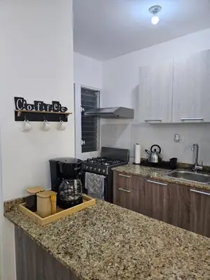 a kitchen with a counter top and a stove top oven at Modern 3BR Apmt Near Airport & Beach in San Isidro