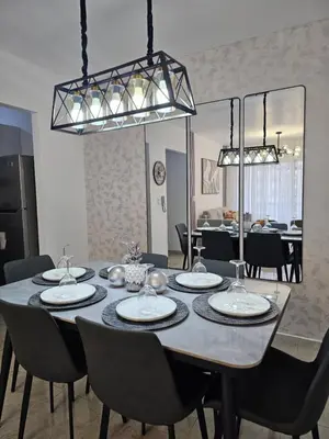a dining room table with chairs and a large chandelier at Modern 3BR Apmt Near Airport & Beach in San Isidro