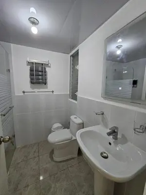 a white bathroom with a toilet and a sink at Modern 3BR Apmt Near Airport & Beach in San Isidro