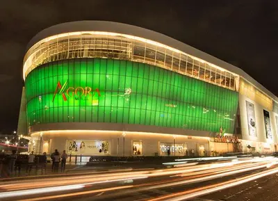 a large building with a green facade at night at Céntrico y acogedor apartartamento con Wifi y Parqueo gratis in Santo Domingo