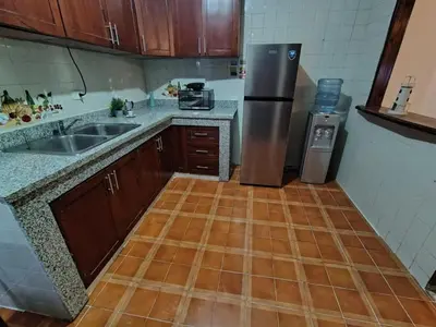 a kitchen with a wooden floor and a stainless steel refrigerator at Céntrico y acogedor apartartamento con Wifi y Parqueo gratis in Santo Domingo