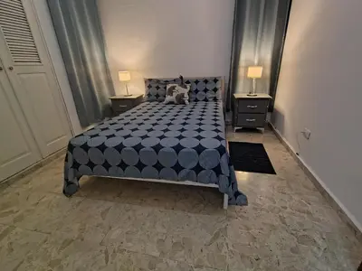a bedroom with a large bed with two night stands at Céntrico y acogedor apartartamento con Wifi y Parqueo gratis in Santo Domingo