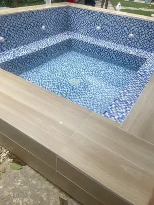 a swimming pool with blue tiles on top of it at Villa Linda in Polo
