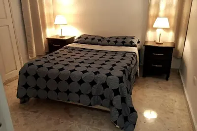 a bedroom with a bed and two night stands with lamps at Exclusive Apartment Free WiFi and Parking in Santo Domingo