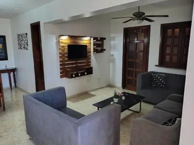 a living room with two couches and a tv at Exclusive Apartment Free WiFi and Parking in Santo Domingo