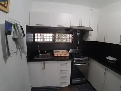 a small kitchen with a stove and a sink at Apartment 150m from the beach with pool in Boca Chica