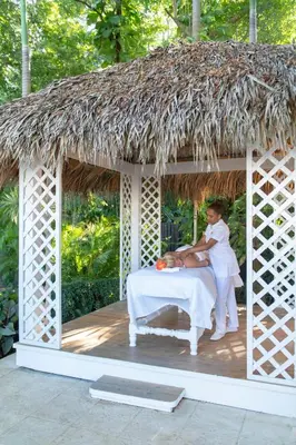 a woman sitting on a bed in a gazebo at Viva Heavens by Wyndham, A Trademark All Inclusive in San Felipe de Puerto Plata