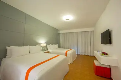 a hotel room with two beds and a television at Viva Heavens by Wyndham, A Trademark All Inclusive in San Felipe de Puerto Plata
