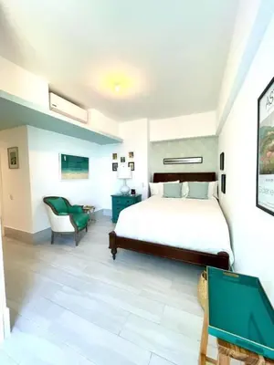 a bedroom with a large bed and a chair at Beachfront FL21 Con Tina Aquarella in La Puntica de Juan Dolio