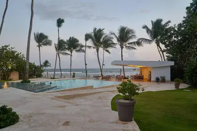 a resort with a pool and palm trees and the ocean at Beachfront FL21 Con Tina Aquarella in La Puntica de Juan Dolio