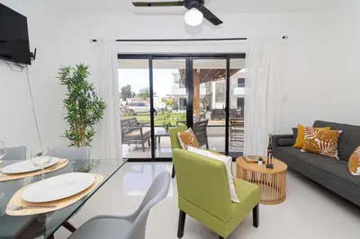 a living room with a couch and a table and chairs at Cozy 1-BR Apartment in Sunshine Bayahibe in San Rafael del Yuma