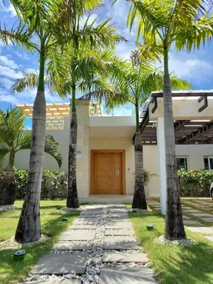a driveway with palm trees in front of a house at Villa Serenity In The Sun in Sosúa