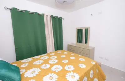 a bedroom with a bed and a green curtain at Peace Place in Santiago de los Caballeros