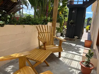 a wooden rocking chair sitting on a porch at Guest House Canephora in Las Galeras in Las Galeras
