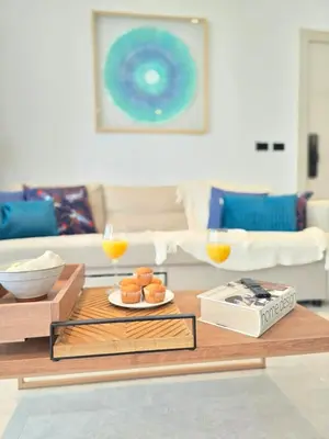 a living room with a table with two glasses of orange juice at Margarita 102 Private Beach Access Aqua Esmeralda Dominicus in La Laguna