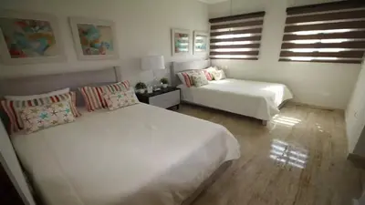 a white bedroom with two beds and a couch at Villa Serenity In The Sun in Sosúa