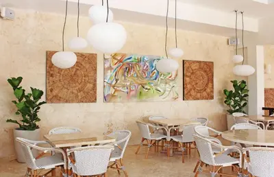 a restaurant with tables and chairs and a painting on the wall at Villa Serenity In The Sun in Sosúa