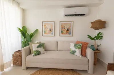 a living room with a couch with pillows at The beach, my happy place- One bedroom Apartment in Puerto Plata