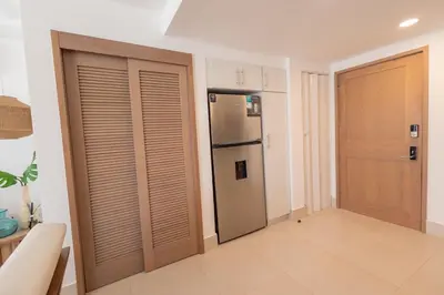 a kitchen with a refrigerator and a sliding door at The beach, my happy place- One bedroom Apartment in Puerto Plata