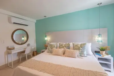 a bedroom with a large bed and a mirror at The beach, my happy place- One bedroom Apartment in Puerto Plata