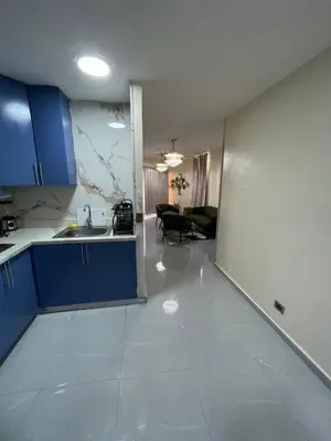 a kitchen with blue cabinets and a living room at Luxury apartment near Jumbo in San Pedro de Macorís