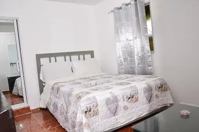 a bedroom with a bed with a quilt on it at Yolanda's house in Bayaguana