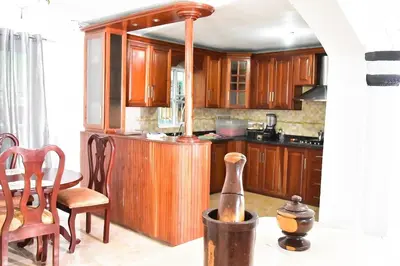 a kitchen with wooden cabinets and a table and chairs at Yolanda's house in Bayaguana