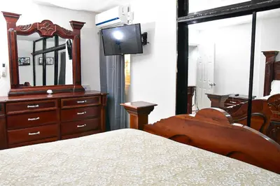 a bedroom with a bed and a mirror and a dresser at Yolanda's house in Bayaguana