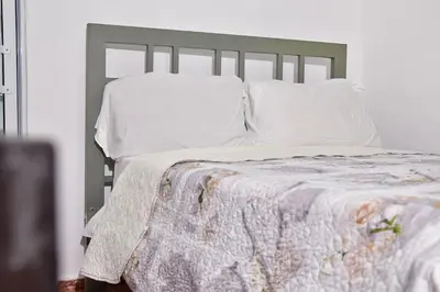 a bed with white sheets and pillows in a bedroom at Yolanda's house in Bayaguana