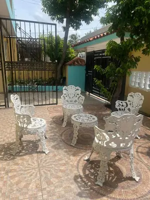 a group of white chairs and tables on a patio at Beautiful Caribbean Coast Residence in Santo Domingo