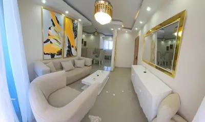 a living room with white furniture and a large mirror at Apartamento in Santo Domingo