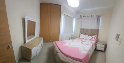 a bedroom with a pink bed and a box at Apartamento in Santo Domingo