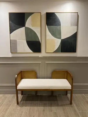a bench in a room with two paintings on the wall at Caonabo35 Elegancia Boutique en Santo Domingo 2 in Santo Domingo